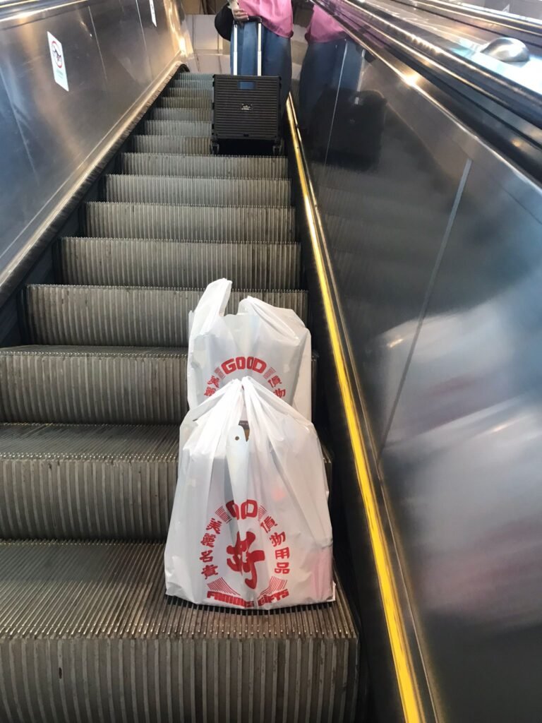 帶上兩袋清酒坐電梯去屯門西鐵站交收